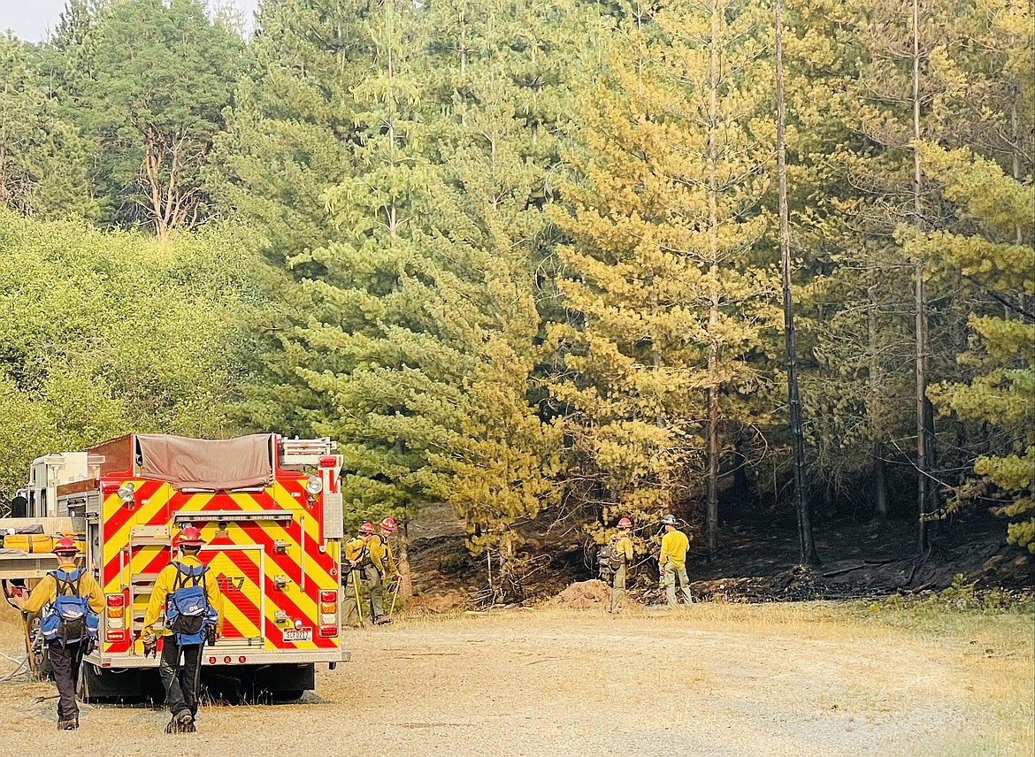 Crews from Shoshone County Fire District No. 2 along with the Idaho Department of Lands survey the scene of a small roadside wildfire that they contained near Galena Ridge on Saturday afternoon.