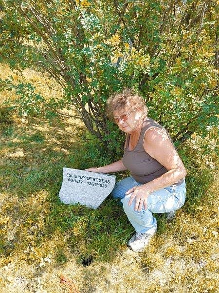 Ellen Matz displays a headstone at the DeBorgia Cemetery. A group of volunteers have worked hard to refurbish the cemetery and recently installed a columbarium. (Photo courtesy Ellen Matz)