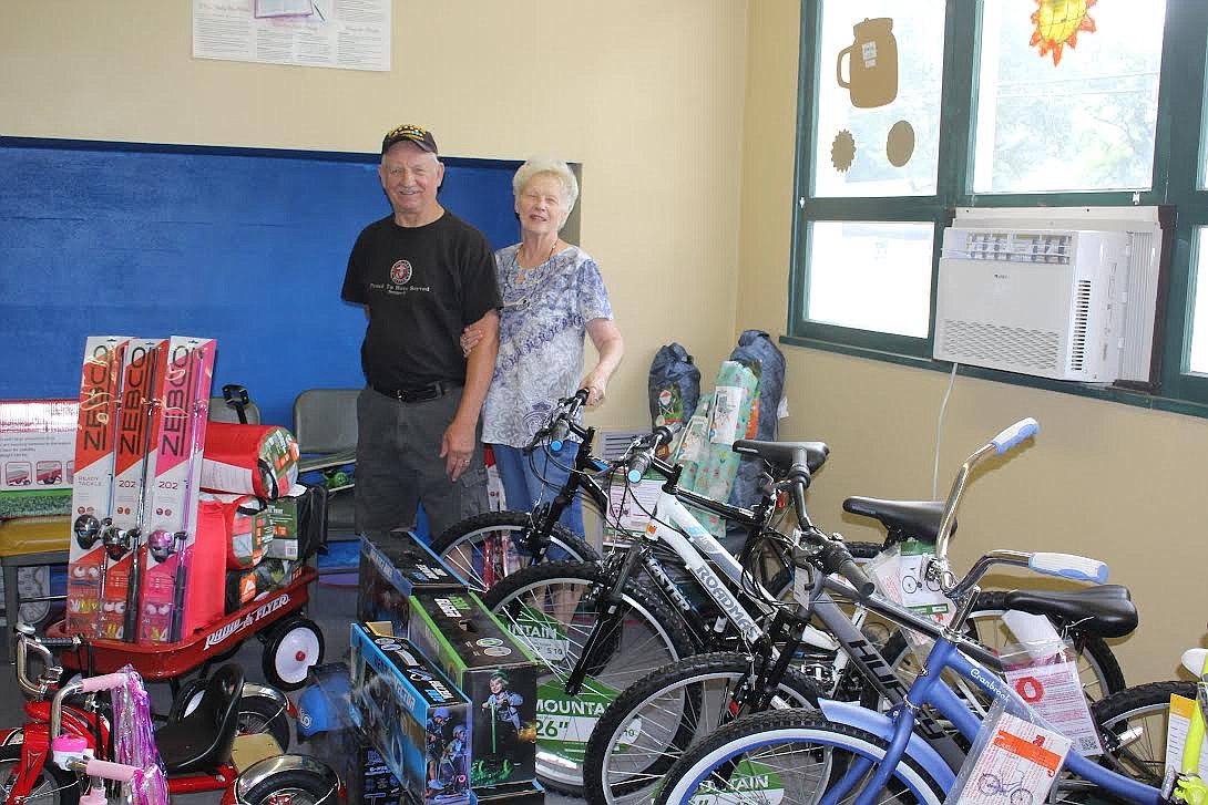 Mike and Sue Neal of Living Waters Worship Center show off the selection of items which will be in the drawing for kids at the Mineral County Fair this weekend. (Monte Turner/Mineral Independent)