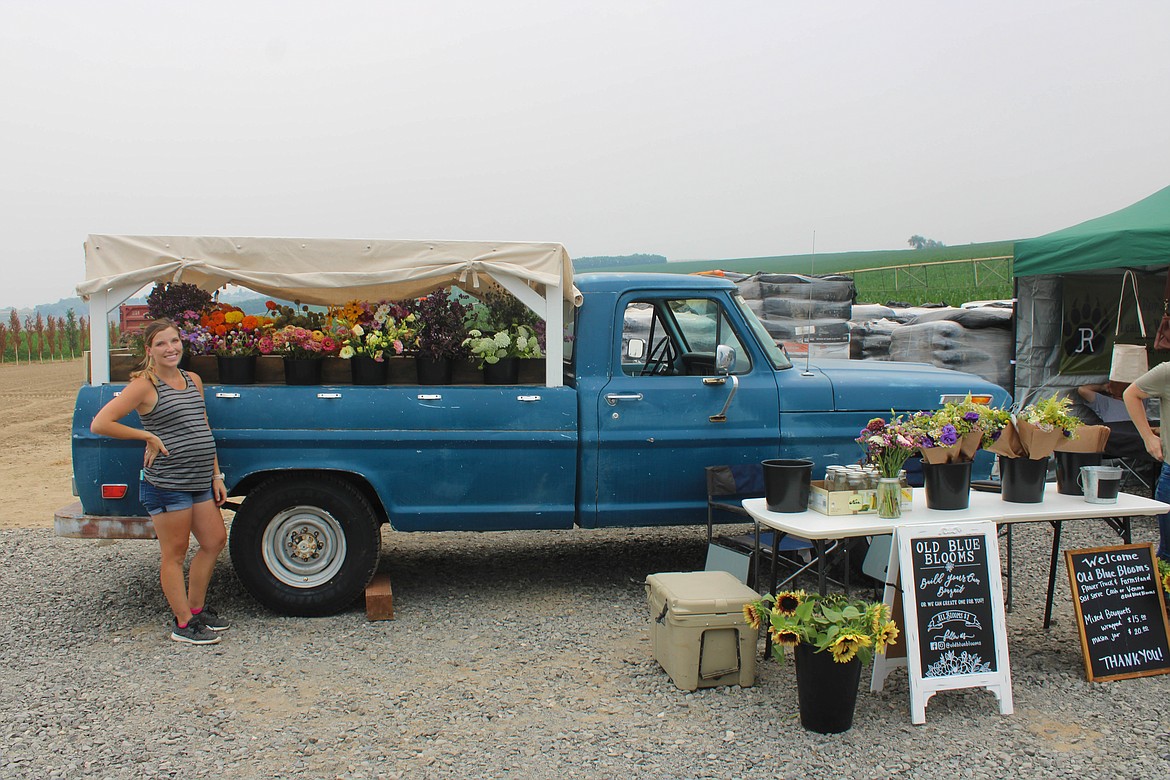 Old Blue Blooms owner Kelsey Jans poses before her display at the Seed Cupboard Nursery Flower Festival on Saturday.