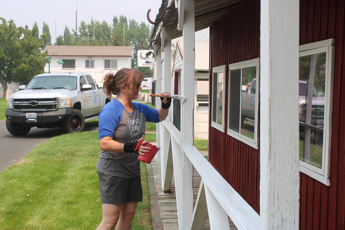 Windermere volunteer Danielle Boss paints the History Barn at the Grant County Fairgrounds on Saturday.