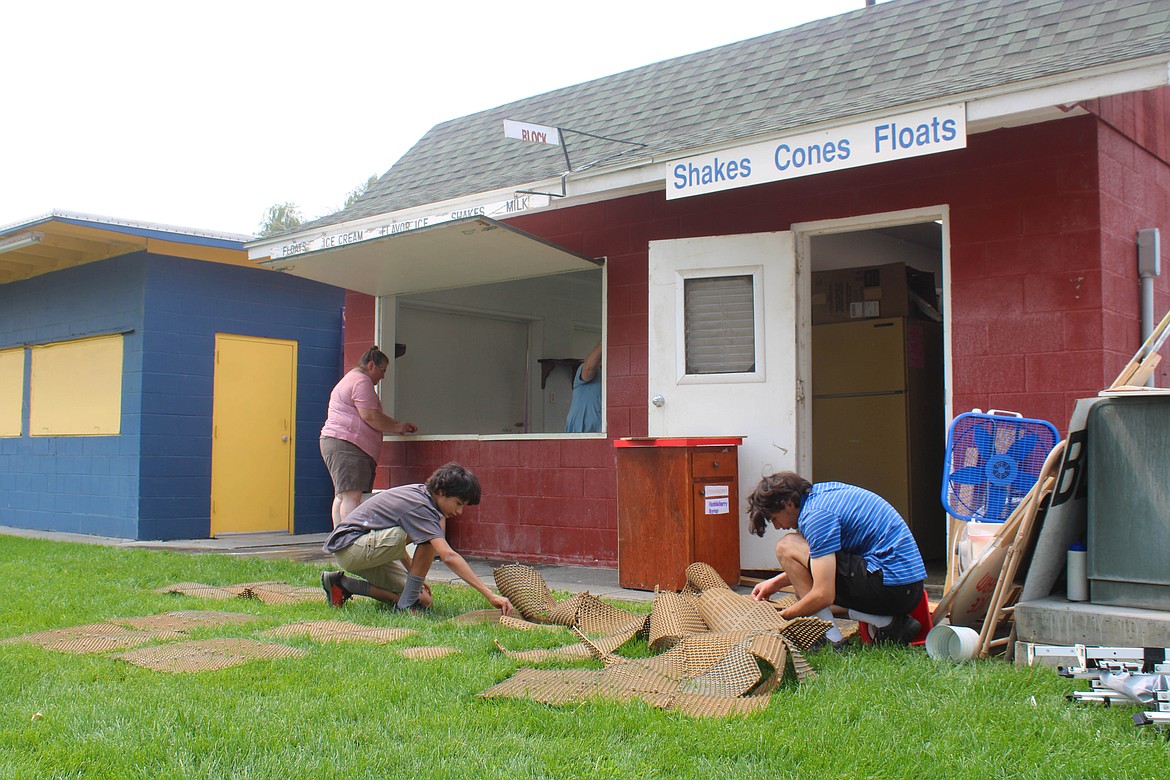 Volunteers clean out vendor shacks at the Grant County Fairgrounds on Saturday.