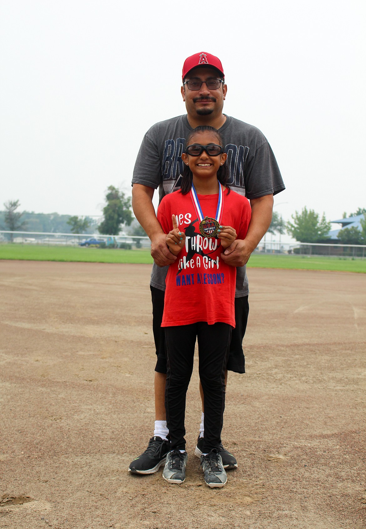 Mya Martinez and her dad, Ray Martinez, pose for a photo Sunday morning at Larsen Playfield in Moses Lake with Mya wearing her medal from the Class A 10U National Championship tournament in North Mankato, Minn.