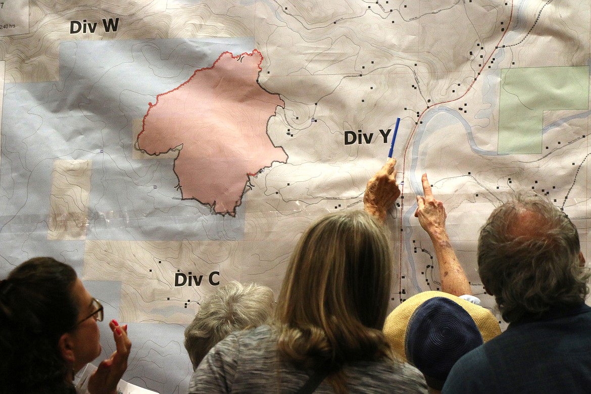 Community members look at a map at Monday's community meeting about updates on the Pioneer Fire. A Type 3 fire team expects to have the wildfire 100% contained before the end of the week.