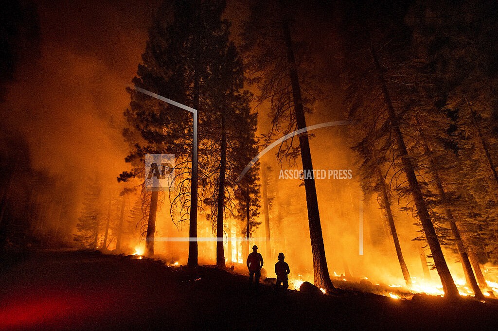 Cal Fire Capts. Derek Leong, right, and Tristan Gale monitor a firing operation, where crews set a ground fire to stop a wildfire from spreading, while battling the Dixie Fire in Lassen National Forest, Calif., on Monday, July 26, 2021. (AP Photo/Noah Berger)