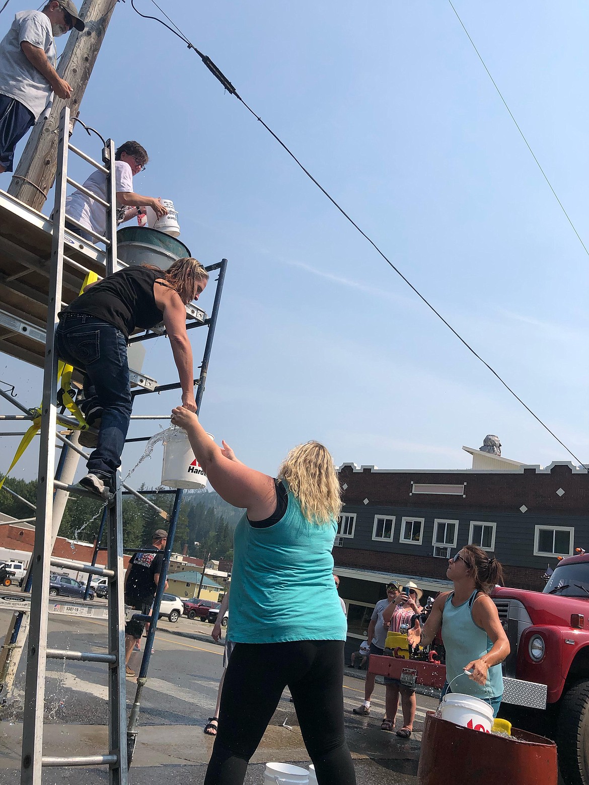 MVFD Chief Rick Smith times Debbie Low, Ronnie Burtlow, Ali Ullrich, and Ashley Elliot as they compete in the bucket brigade challenge.