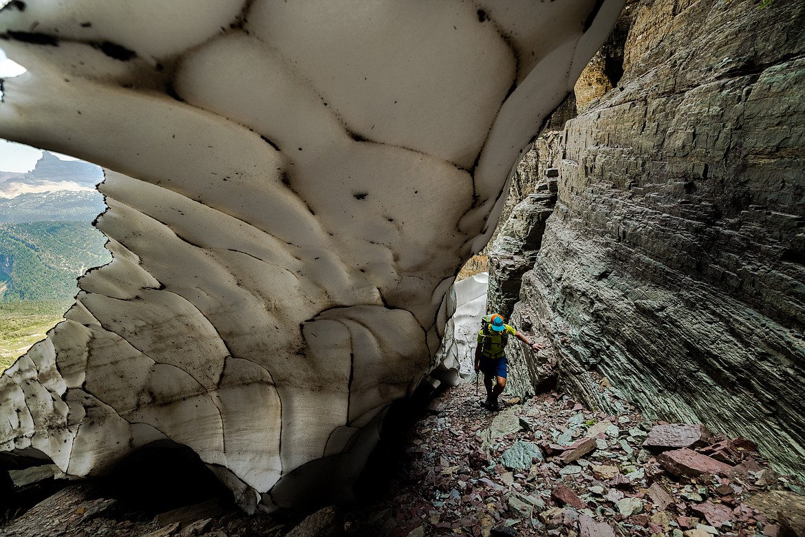 Greg Burfeind climbs along the outer edge of a snowfield blocking a chimney at Almost-a-Dog Pass in Glacier National Park. (Courtesy of Noah Couser)