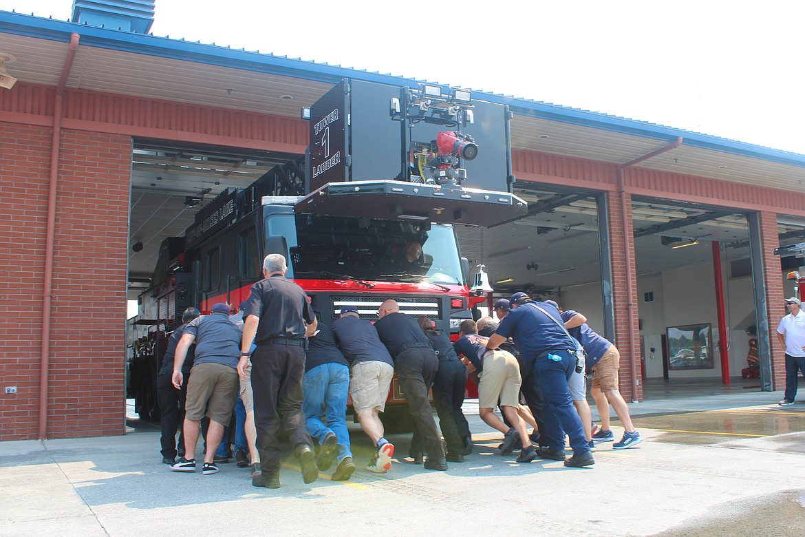 Moses Lake firefighters push the new Ladder 1 into the apparatus bay on Tuesday.
