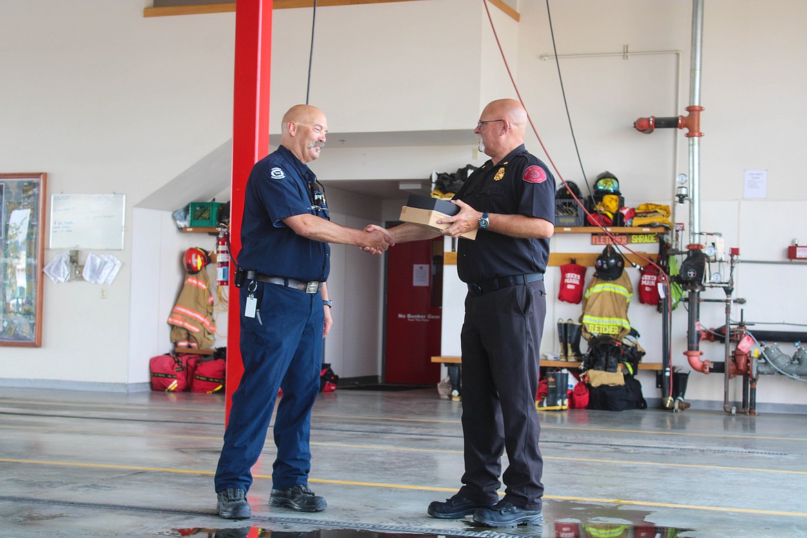 Moses Lake Fire Department acting officer Paul Gueren (right) accepts an award given by MLFD Chief Brett Bastian on Tuesday.
