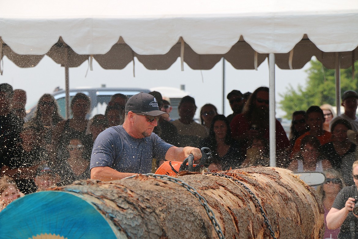 A competitor works to saw through a log at Saturday's Timber Days competition.