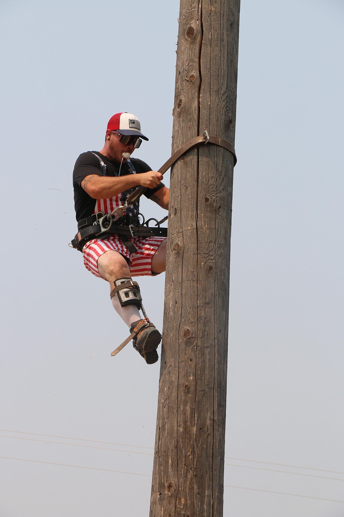 A competitor races down with the egg during Saturday's pole climbing contest at Timber Days.
