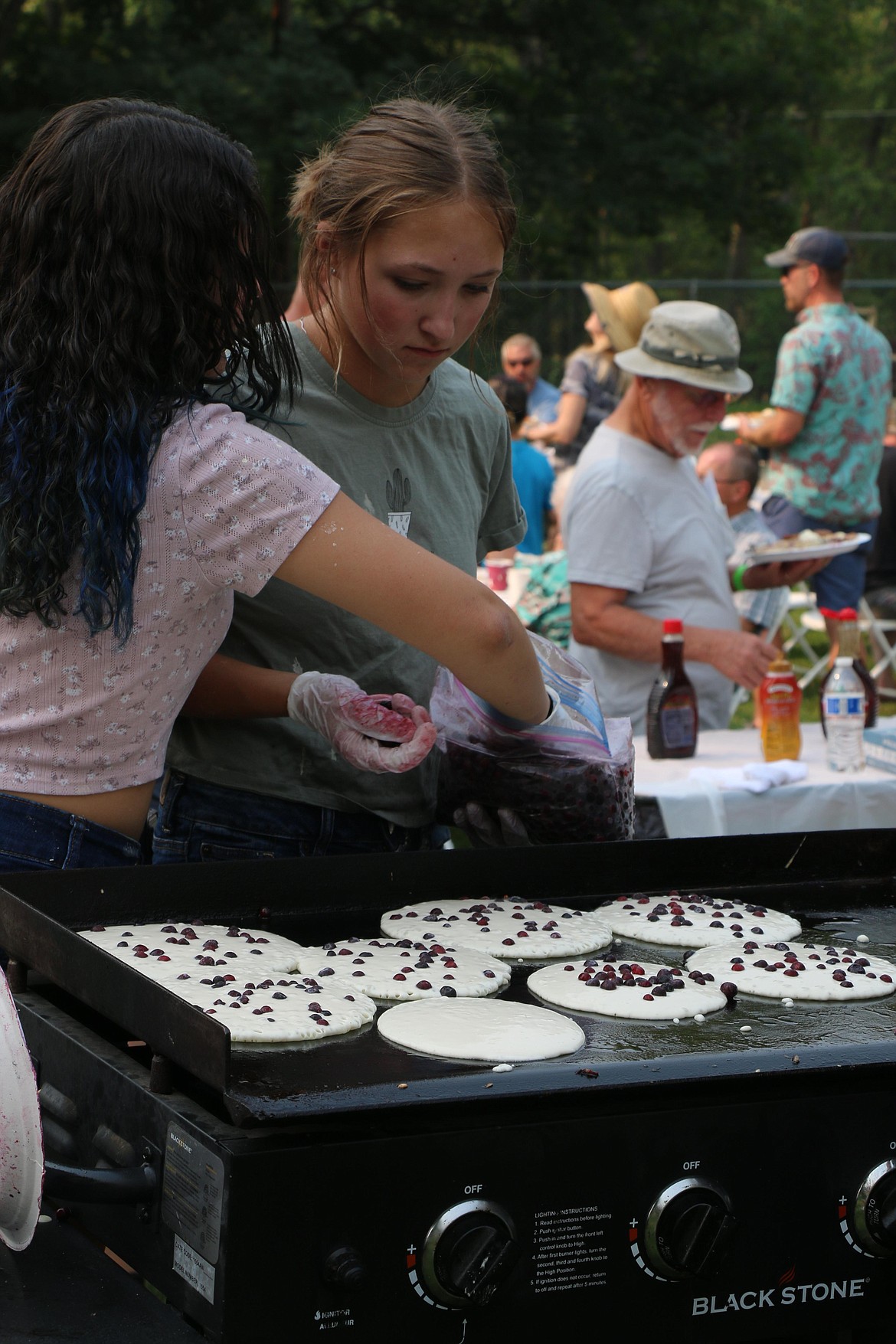 Priest River Lamanna Spartan Adult Boosters volunteers add huckleberries to the pancakes during Saturday's pancake breakfast following the Run for the Berries fun run.