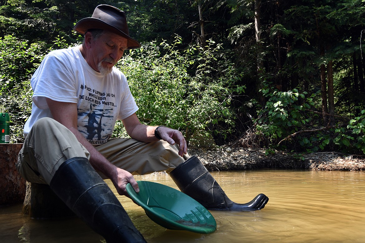 Barry Mills sits in Libby Creek, panning for gold with the Northwest Montana Gold Prospectors. (Jeremy Weber/Daily Inter Lake)
