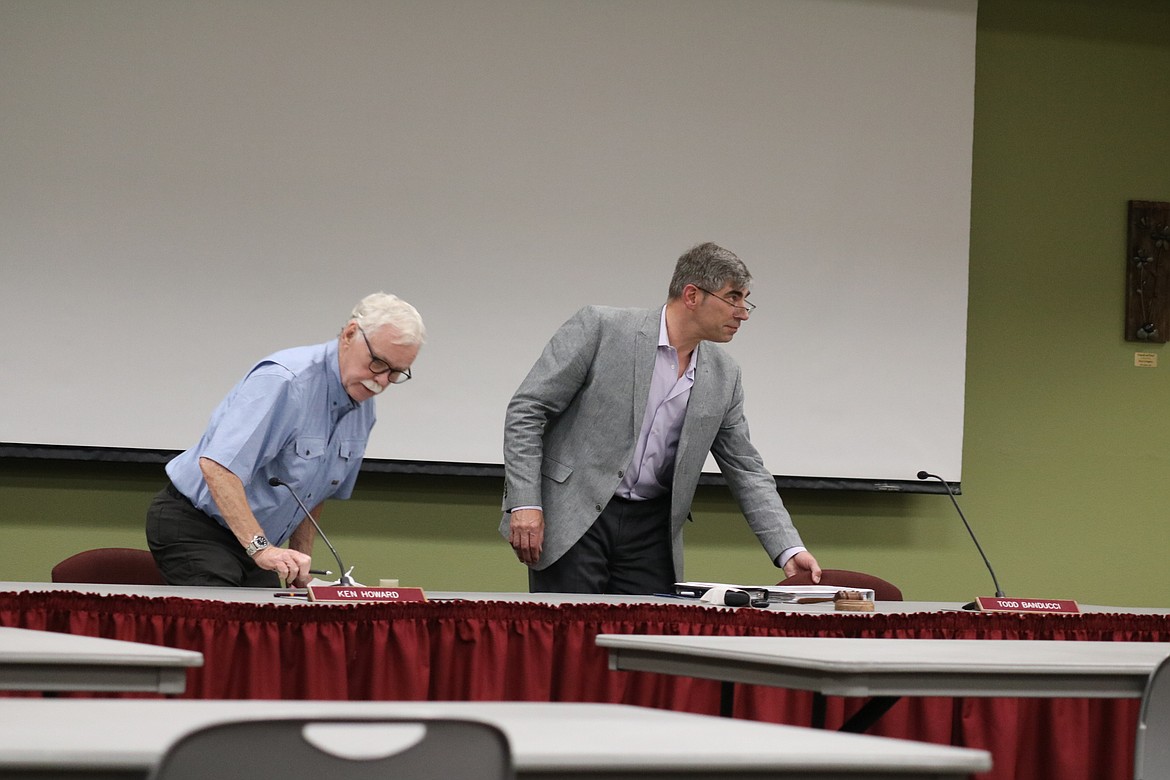 Trustee Ken Howard, left, and board chair Trustee Todd Banducci gather their belongings after a short board meeting Wednesday night in which action to renew President Rick MacLennan's contract was tabled until September. HANNAH NEFF/Press