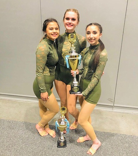 Darianna Vela, right, holds up a trophy with her teammates after taking first place for the third straight year at the Showstopper Dance Competition in May 2019.