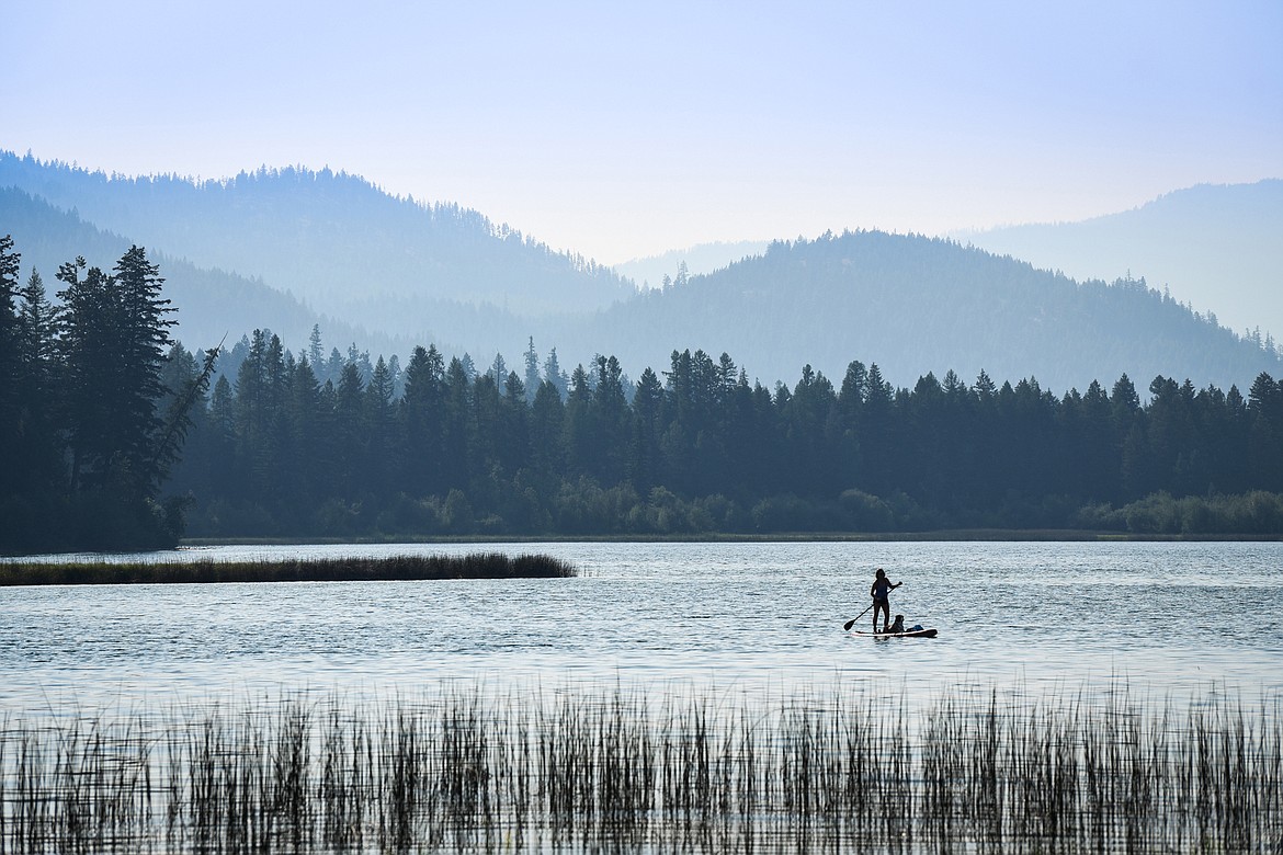 A woman paddleboards with her canine companion on Upper Thompson Lake in Lincoln County on Saturday, July 24, 2021. (Casey Kreider/Daily Inter Lake)