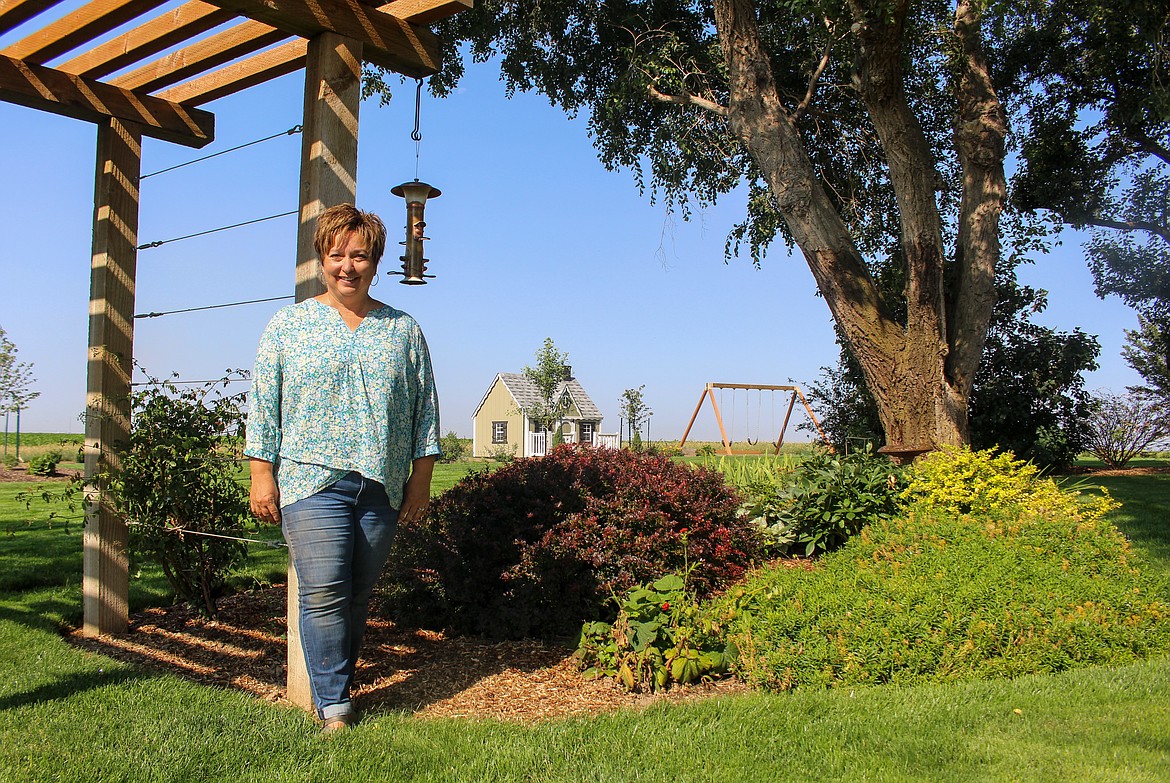 Julie Phipps stands beside one of many garden beds nestled around her yard at her home outside Moses Lake.