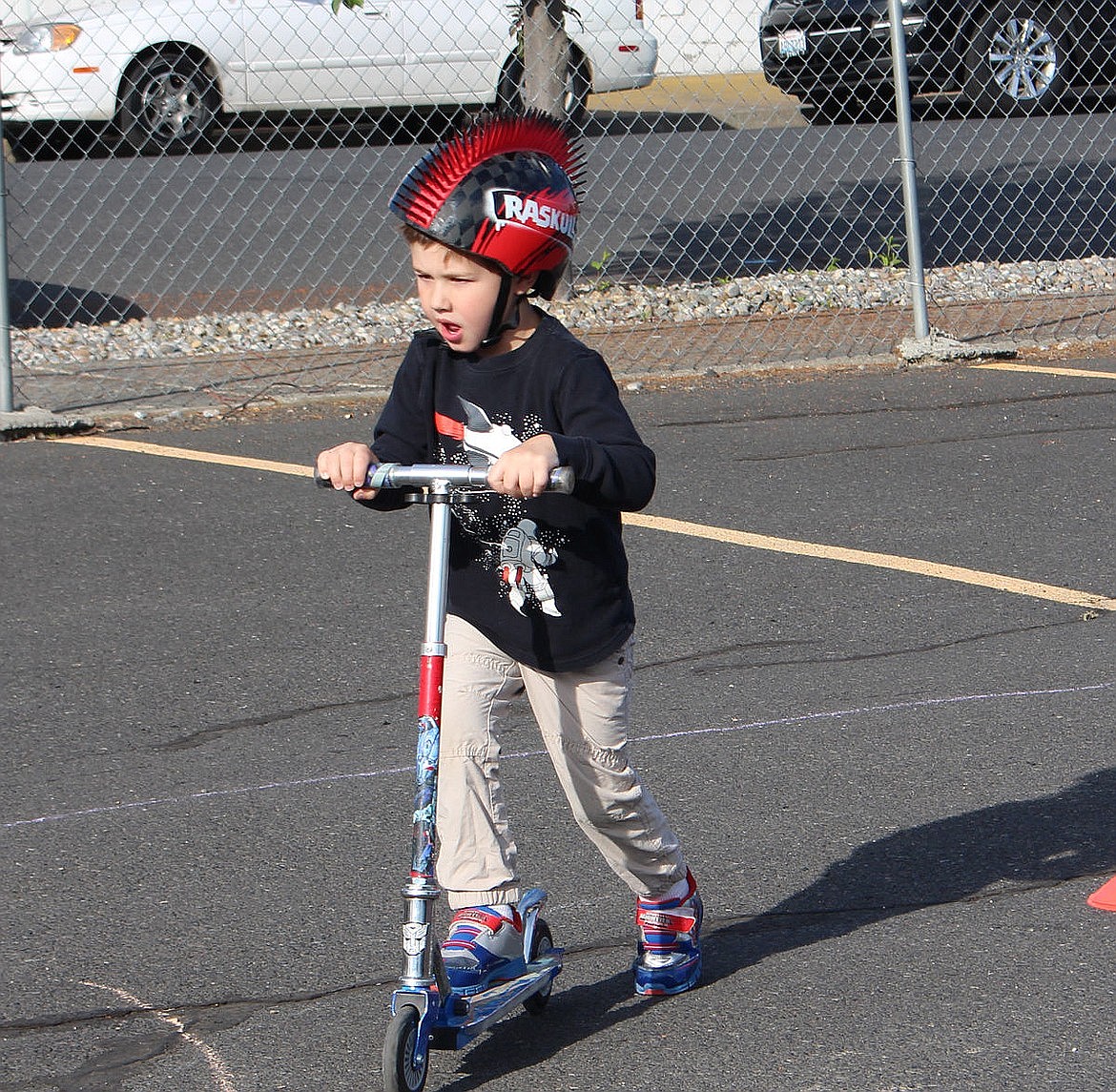 A scooter rider navigates the course at the Peninsula Elementary Bike Rodeo in 2016.