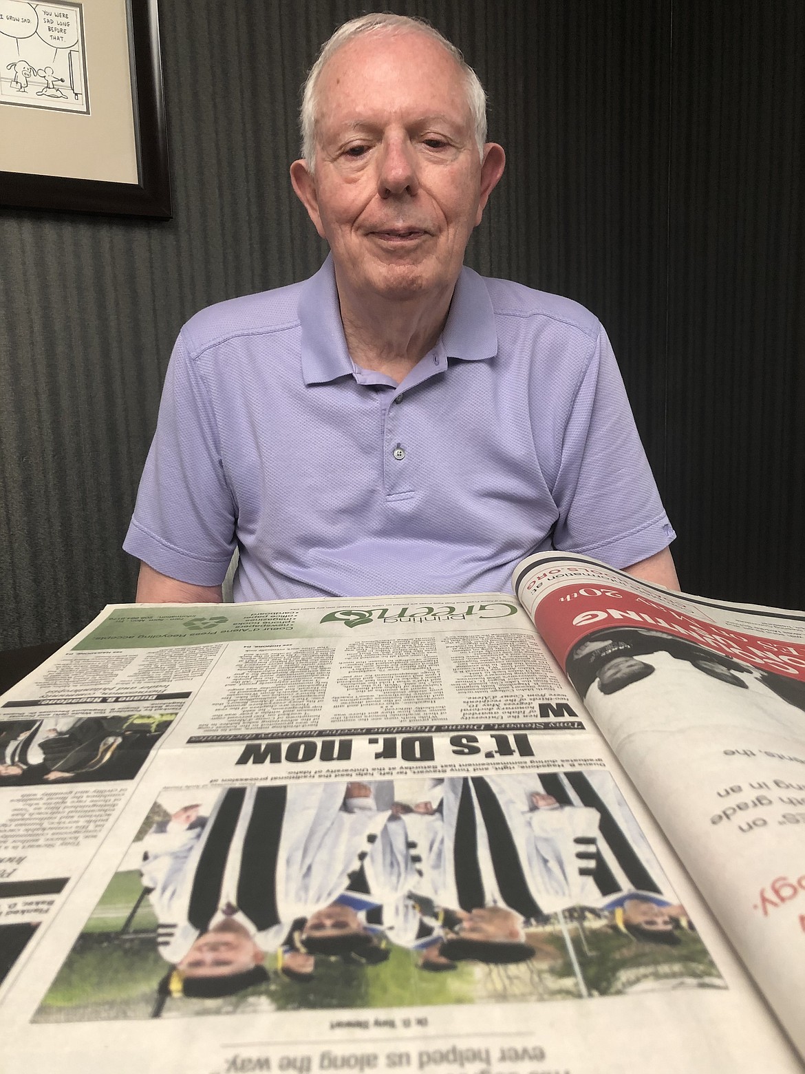 Tony Stewart looks over a Press article from 2008, when he and Duane Hagadone were awarded honorary doctoral degrees from the University of Idaho.