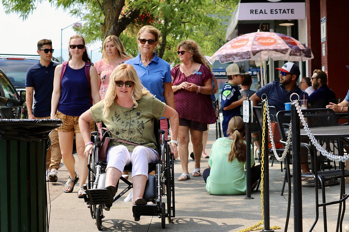 Councilwoman Christie Wood navigates through Sherman Avenue on a wheelchair in a challenge organized by the Coeur d’Alene pedestrian and bicycle advisory committee to help city officials understand the difficulties faced by the disabled community. HANNAH NEFF/Press