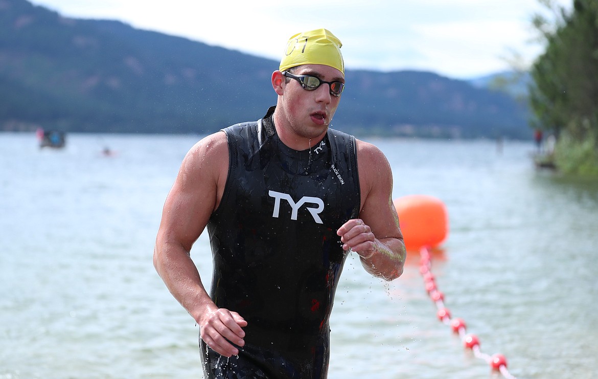 Logan Robillard, a 17-year-old from Lake City High School, runs across the line to capture first overall in the 26th annual Long Bridge Swim on Saturday. He finished with a time of 34:01.