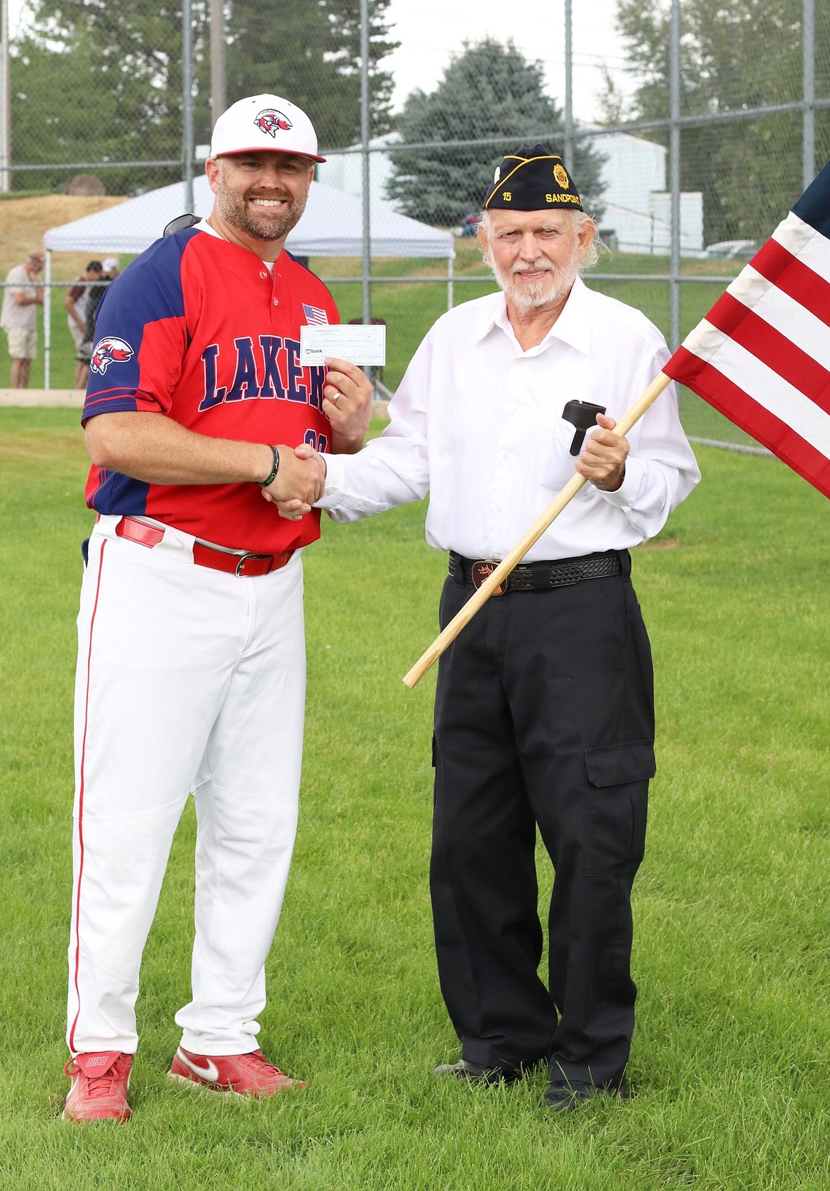 North Idaho Lakers General Manager KC MacDonald (left) accepts a $500 donation from Tom Spade of American Legion Post 15 on Saturday.