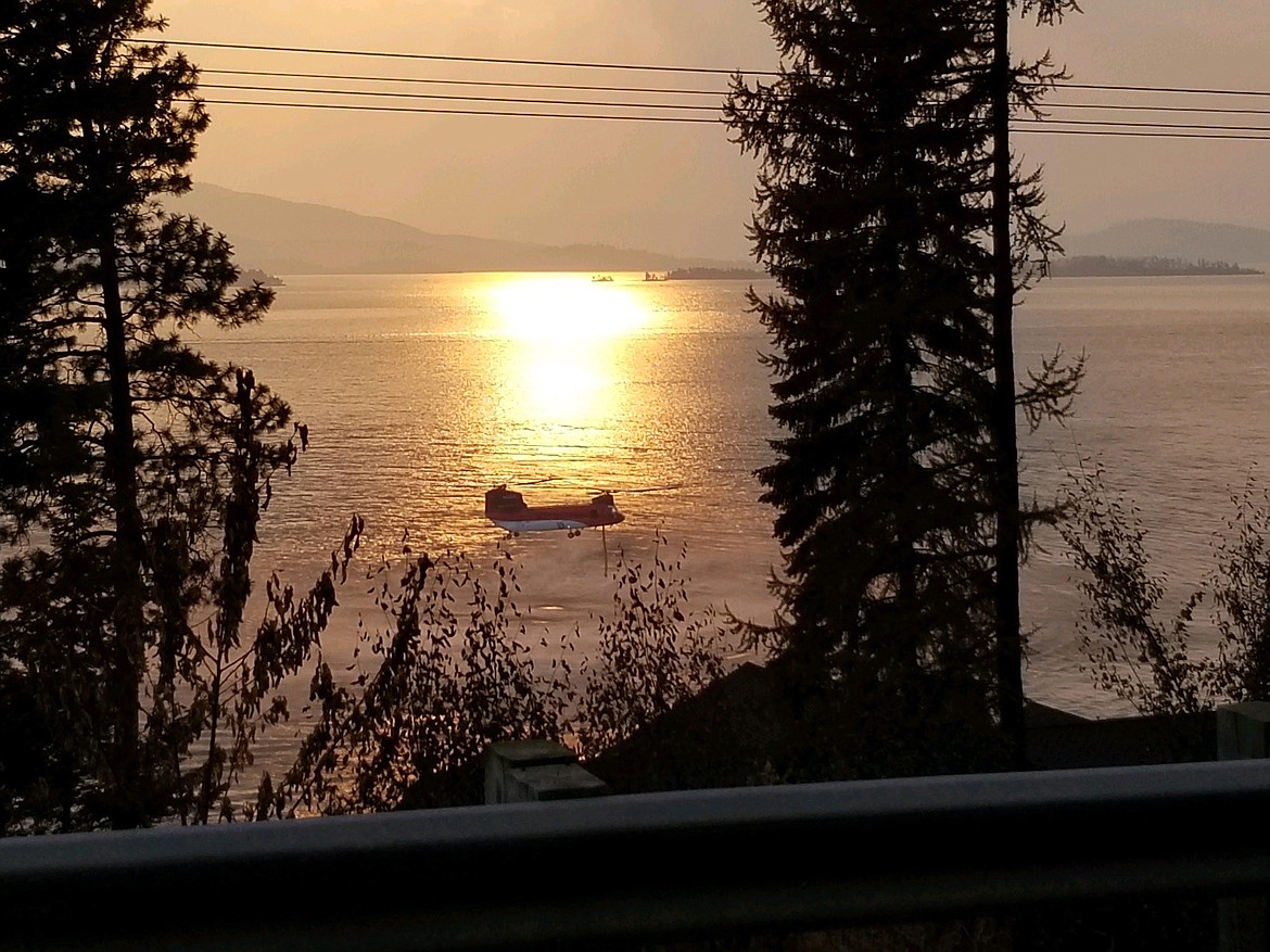 A helicopter assigned to the Boulder 2700 Fire draws water from Flathead Lake. (InciWeb)