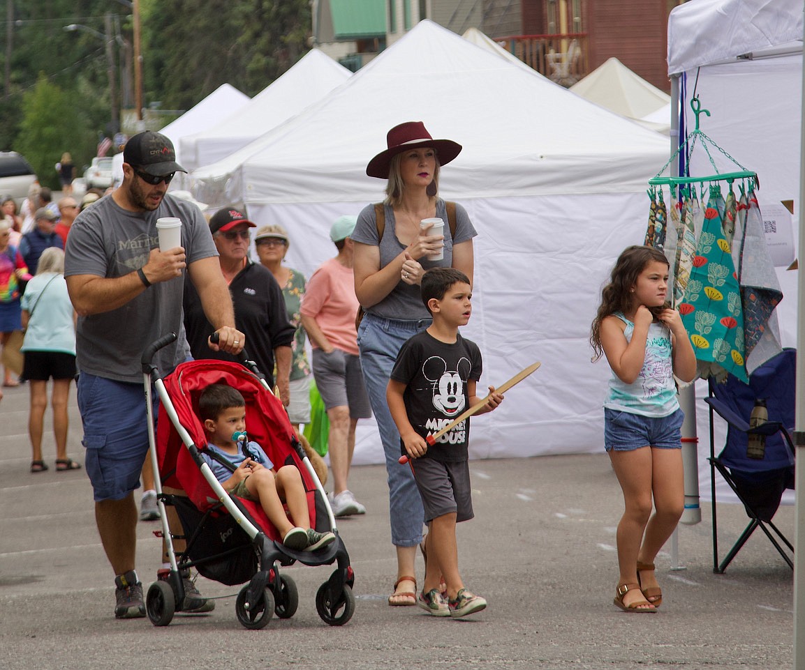 A family drifts through downtown Bigfork while dad and mom enjoy their morning coffee at the Bigfork Festival of the Arts. (Kay Bjork photo)