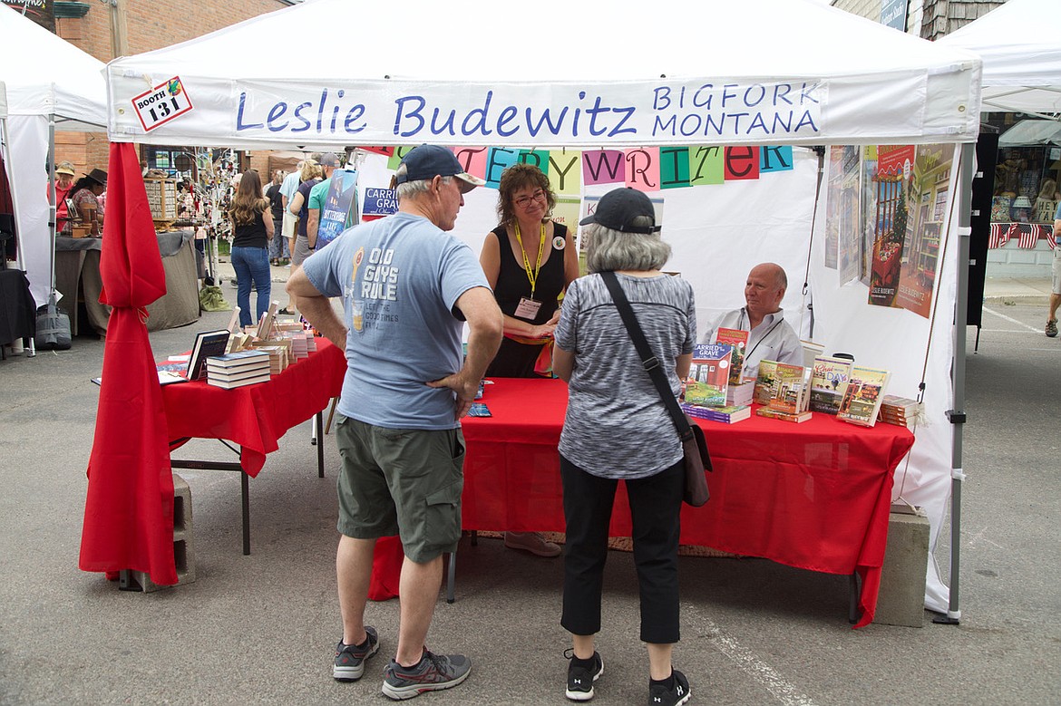 Local mystery writer Leslie Budewitz greets visitors to her booth featuring her locally based books.