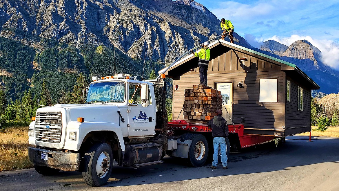 Workers with Kalispell Structural Movers prepare a two-bedroom cabin to be unloaded from a flatbed truck at the Rising Sun Campground in Glacier National Park on Monday, Aug. 9, 2021. A dozen Columbia Falls High School students built the cabin through Glacier's School-to-Park Program. (Chad Sokol/Daily Inter Lake)