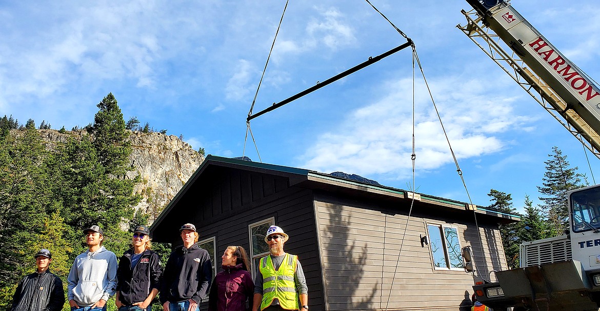 Columbia Falls High School students and Glacier National Park carpenter Bob Jellison pose for photos in front of a two-bedroom cabin they built shortly after it was placed at Glacier's Rising Sun Campground on Monday, Aug. 9, 2021. (Chad Sokol/Daily Inter Lake)