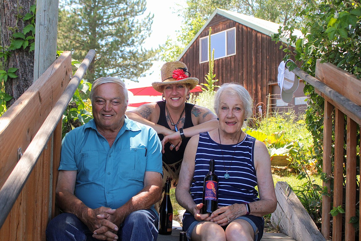 Left to right, Dennis, Kathleen and Nancy Parr sit on the steps leading up from the dock beside Moses Lake to the tasting room at Camas Cove Cellars on July 10.