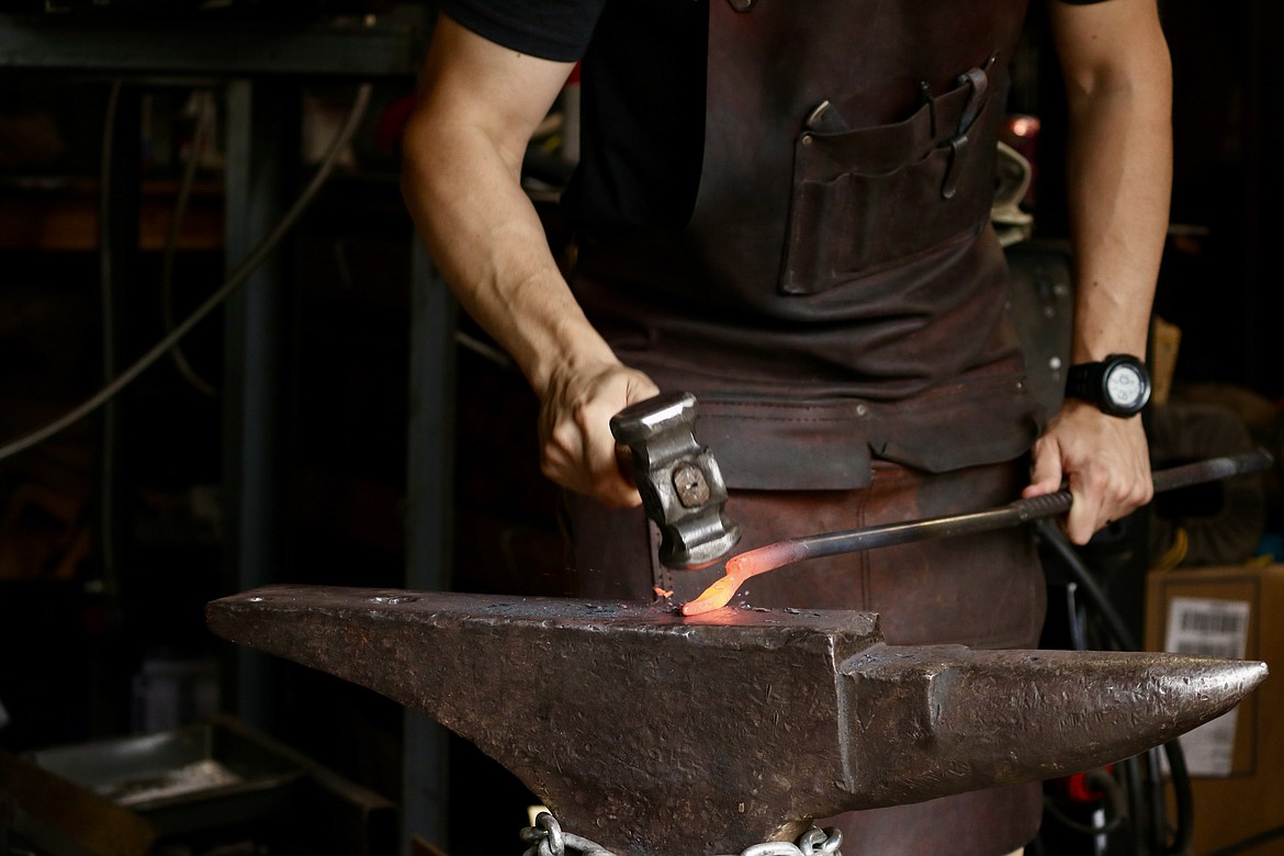 Andrew Hall, a firefighter and Coeur d'Alene resident, hammers away on his anvil in his garage workshop. Hall recently received first place on "Forged in Fire" a competition TV series airing on the History channel. HANNAH NEFF/Press