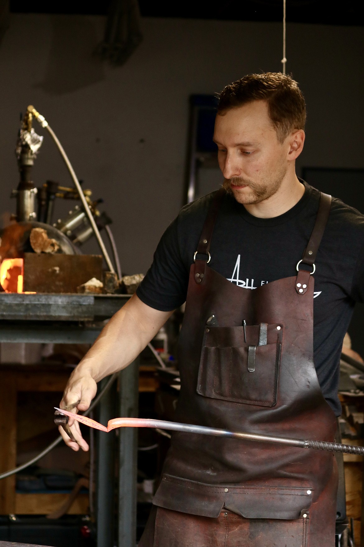 Coeur d'Alene resident and winner on "Forged in Fire" Andrew Hall forges a piece of steel round stock to create a Christmas ornament in his garage workshop. Hall made his first forge about five years ago. HANNAH NEFF/Press