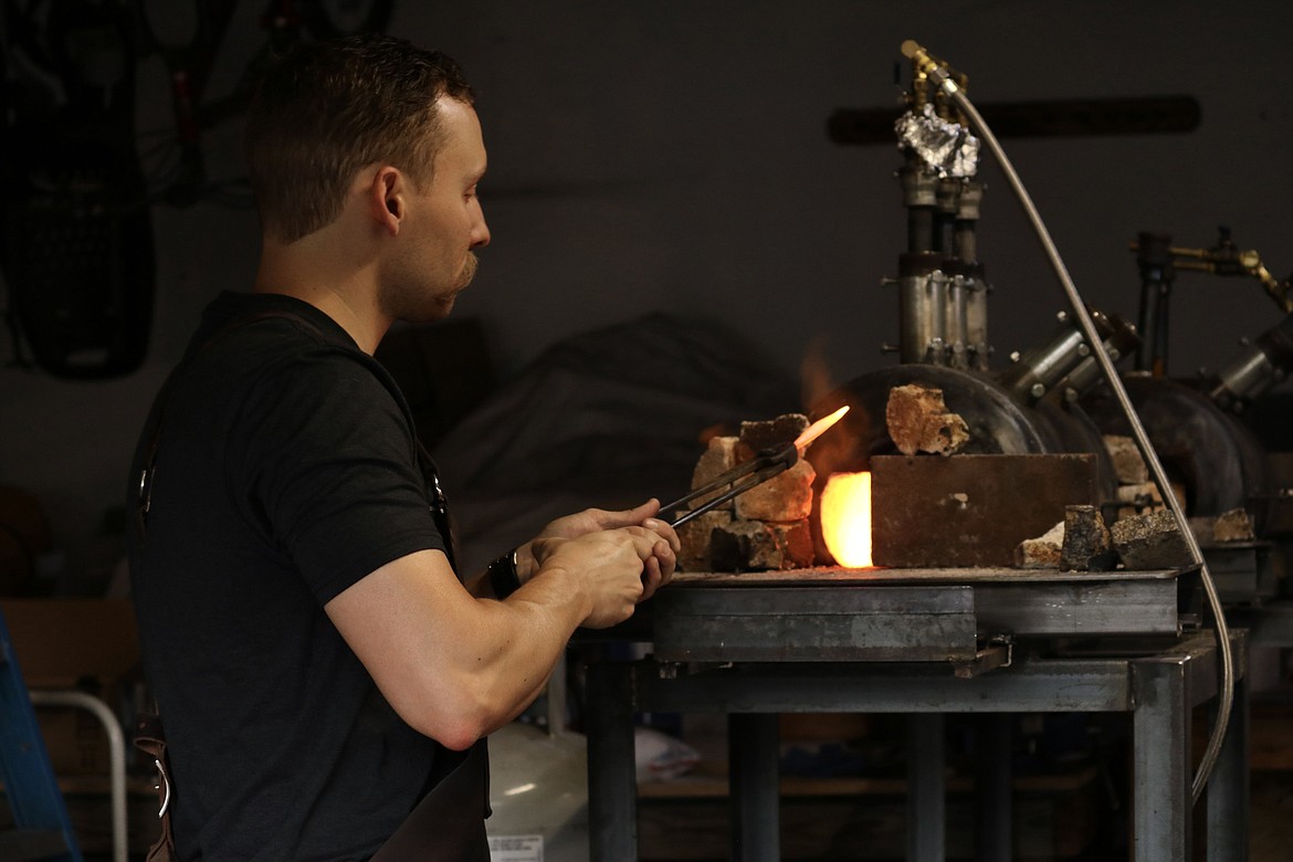 Coeur d'Alene resident Andrew Hall works with his forge in his garage workshop where he created a Damascus sword that won him the championship on "Forged in Fire," a  competition TV series. HANNAH NEFF/Press