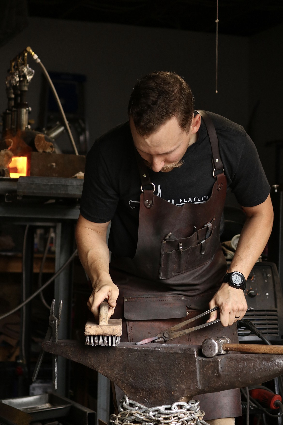 Andrew Hall, a firefighter and recent winner on "Forged in Fire" a competition TV series, puts the finishing touches on a Christmas ornament he forged in the garage of his Coeur d'Alene home. HANNAH NEFF/Press