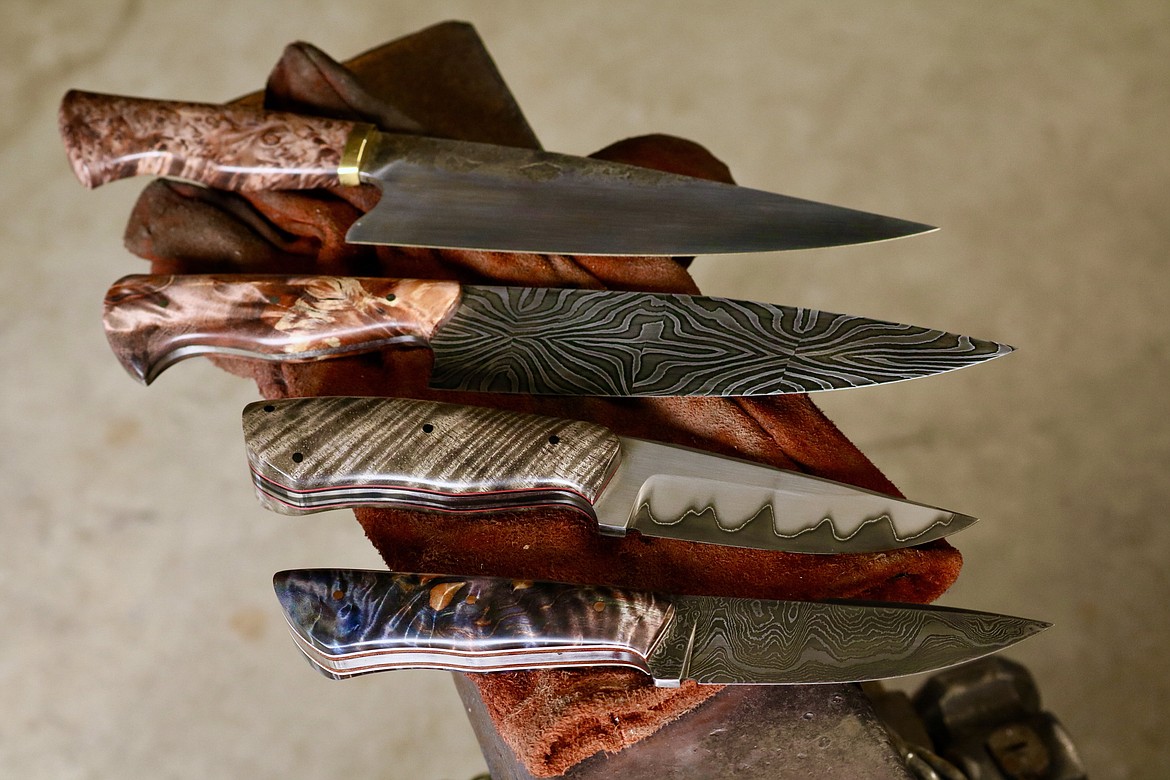 Over the past five years, Coeur d'Alene resident Andrew Hall has made a variety of knives in his garage workshop including these four from top: 80CRV2 forged chef's knife, mosaic pattern Damascus kitchen knife, stainless clad san-mai hunting knife, and the first Damascus knife he made which has over 101 layers of Damascus steel. HANNAH NEFF/Press