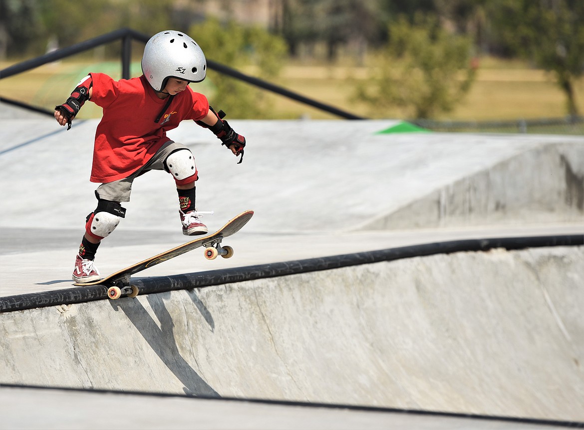 A young skater takes the dive into a bowl at Polson Skatepark. (Scot Heisel/Lake County Leader)