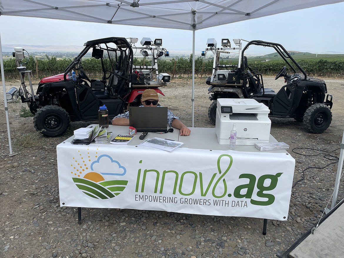 An innov8.ag employee with the company's two souped-up, sensor-packed ATVs, which take pictures and use artificial intelligence to help growers map their orchards and predict their harvest.