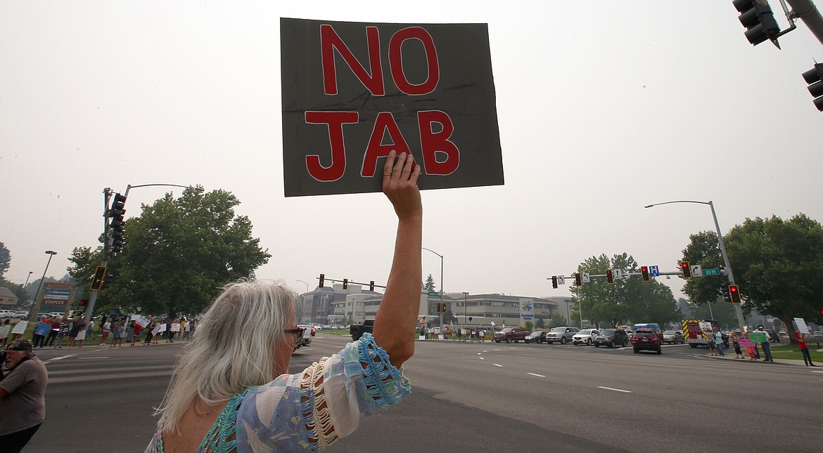 Nancy King holds a sign during a rally against vaccine mandates in Coeur d'Alene on Thursday.