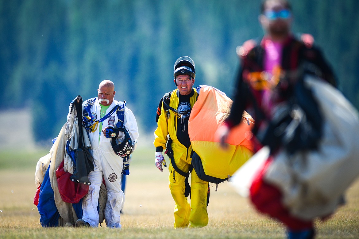 Skydivers carry their gear after a jump at the 2021 Skydive Lost Prairie Boogie at Meadow Peak Skydiving near Marion on Thursday, Aug. 12, 2021. (Casey Kreider/Daily Inter Lake)