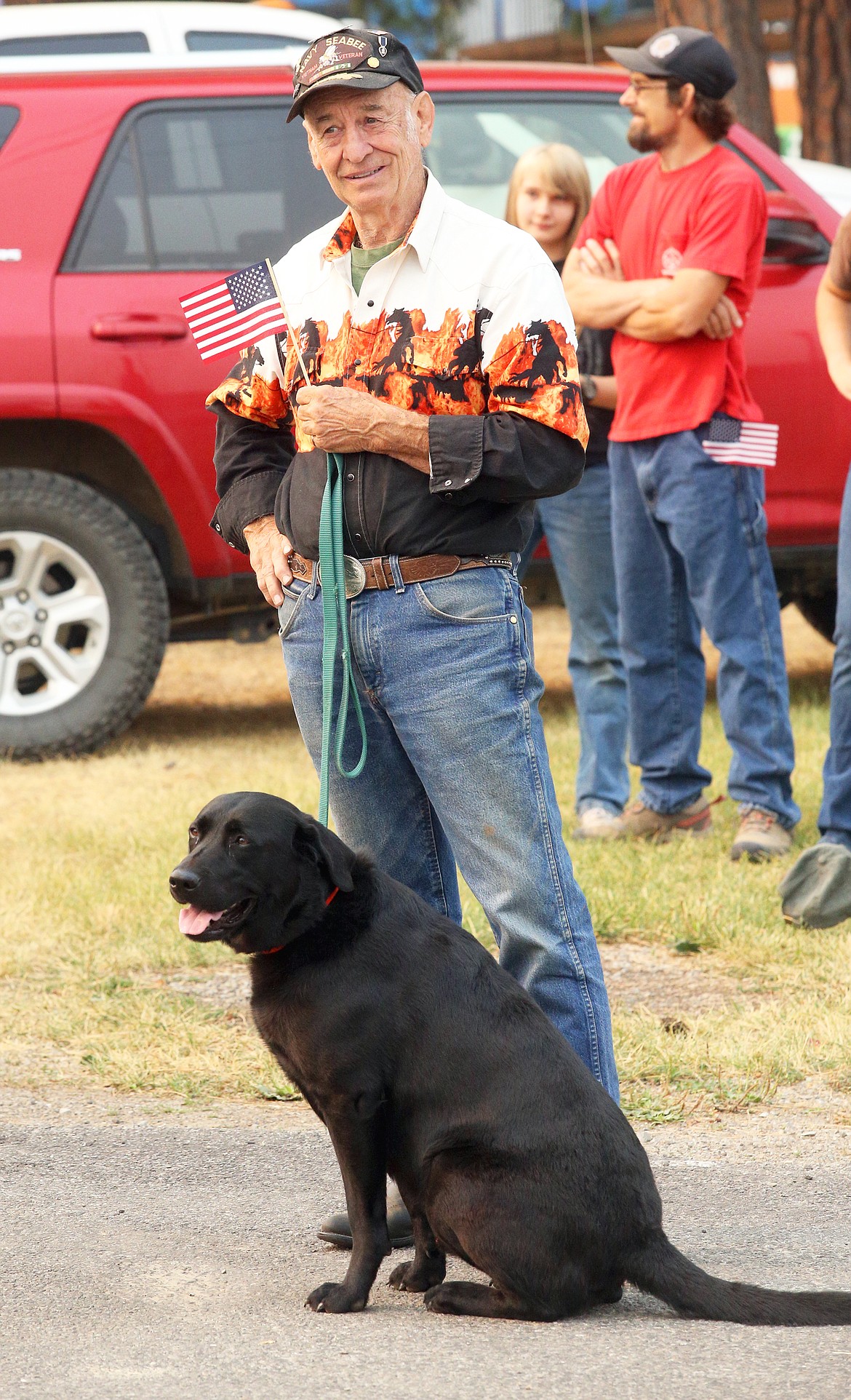 Gary Sylte watches the Athol Daze parade with his black labrador Taylor on Saturday.