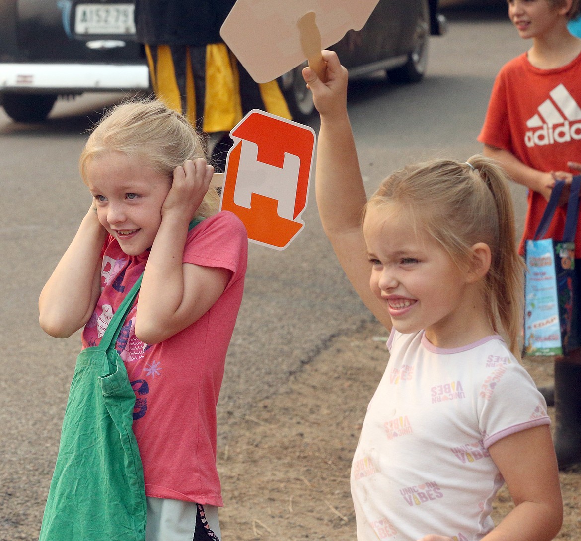 Sisters Eva and Lily Savage react to loud horns during the Athol Daze parade on Saturday.