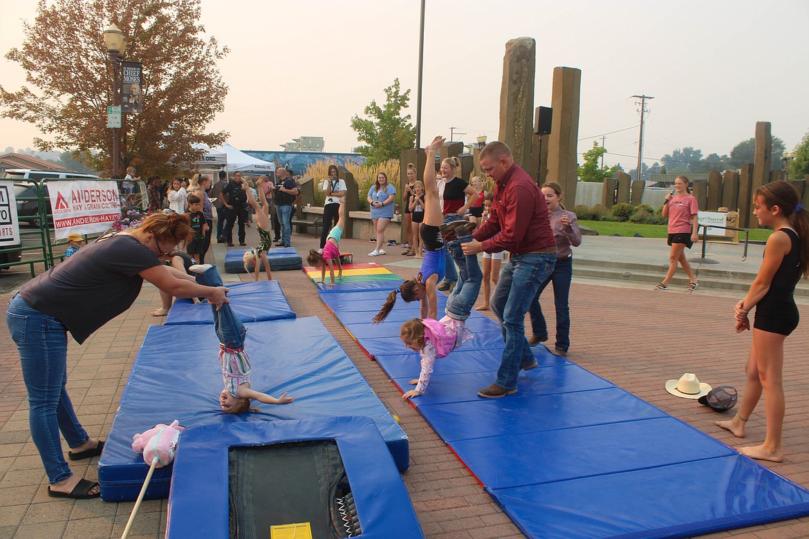 Families step up for a handstand or headstand led by AIM School & Gymnastics at the Cowboy Breakfast Friday morning.