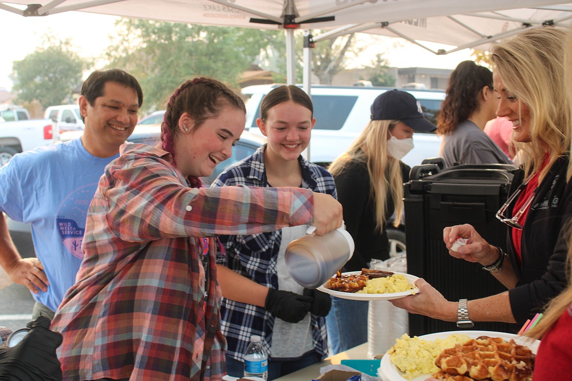 Key Club member Ryan Hays pours syrup at the Cowboy Breakfast Friday morning.