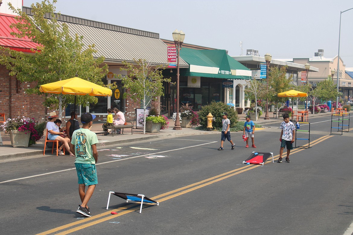 Israel Estrada (left) plays cornhole with his brother, Samuel Estrada (right) at Summer Street on 3rd on Saturday.