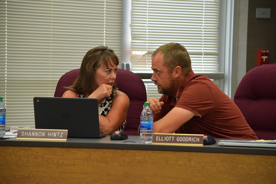 Moses Lake School Board members Shannon Hintz and Elliott Goodrich confer prior to the regular board meeting Thursday.