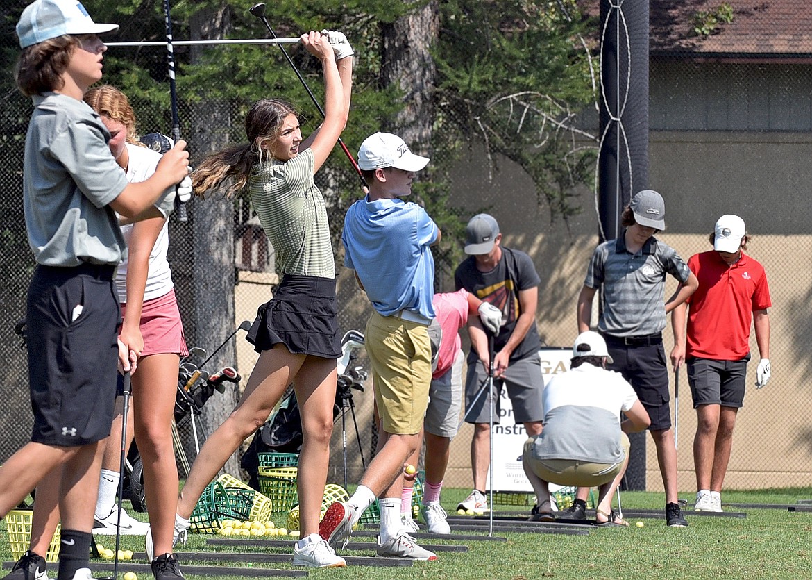 Whitefish senior Anyah Cripe watches her shot as she practices alongside her teammates at the Whitefish Lake Golf Course on Friday. (Whitney England/Whitefish Pilot)