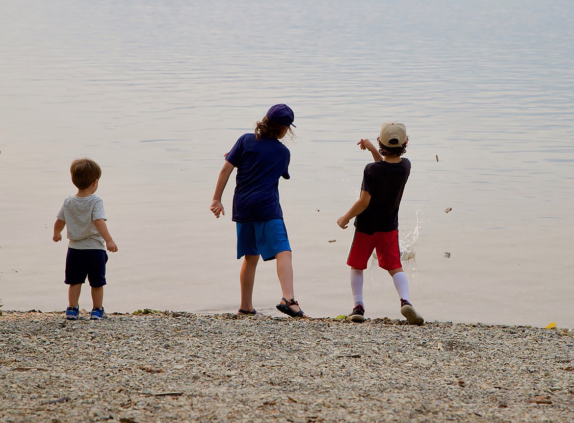 Boys enjoy the classic kid activity of throwing rocks into the lake. (Kay Bjork/For the Bigfork Eagle)