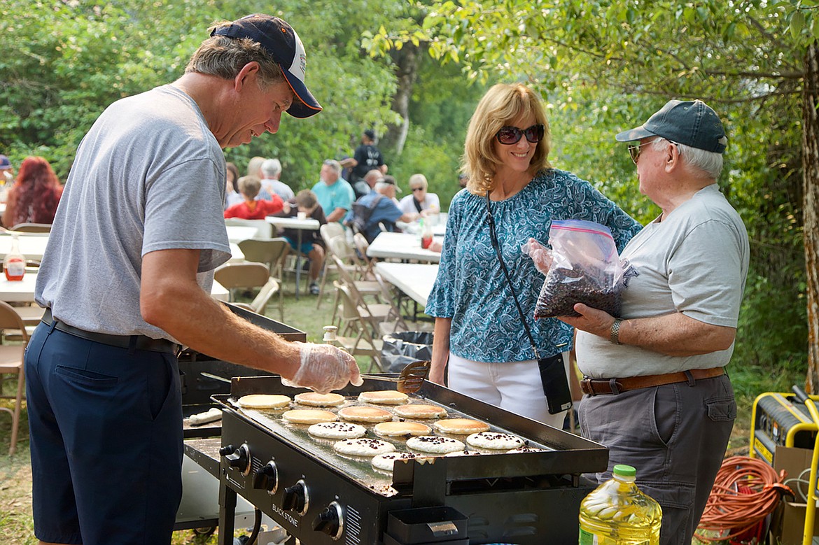 Troy Ehrman mans the grill at the pancake breakfast with help from Sonny Mckenzie. (Kay Bjork/For the Bigfork Eagle)